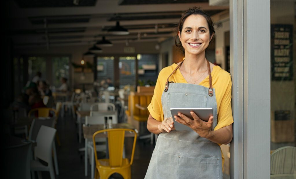 A Waitress Smiling While Holding A Tablet